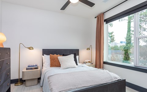 A bedroom with a large bed and a ceiling fan.