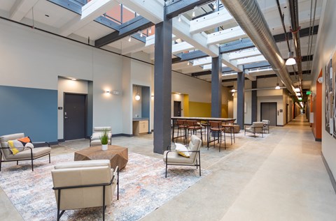 the lobby of a large building with seating and tables