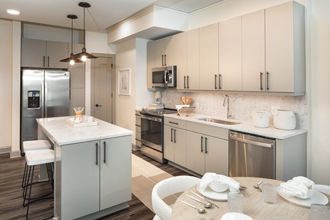 a kitchen with white cabinets and stainless steel appliances and a table