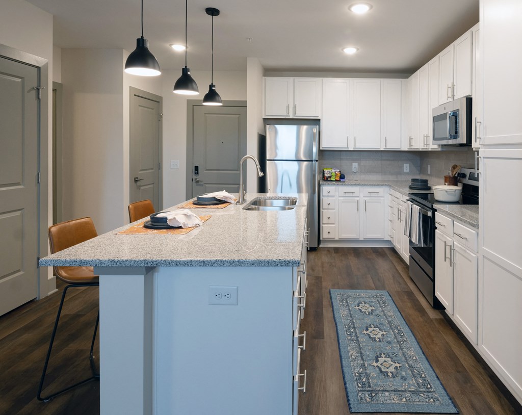 a kitchen with white cabinets and a blue island