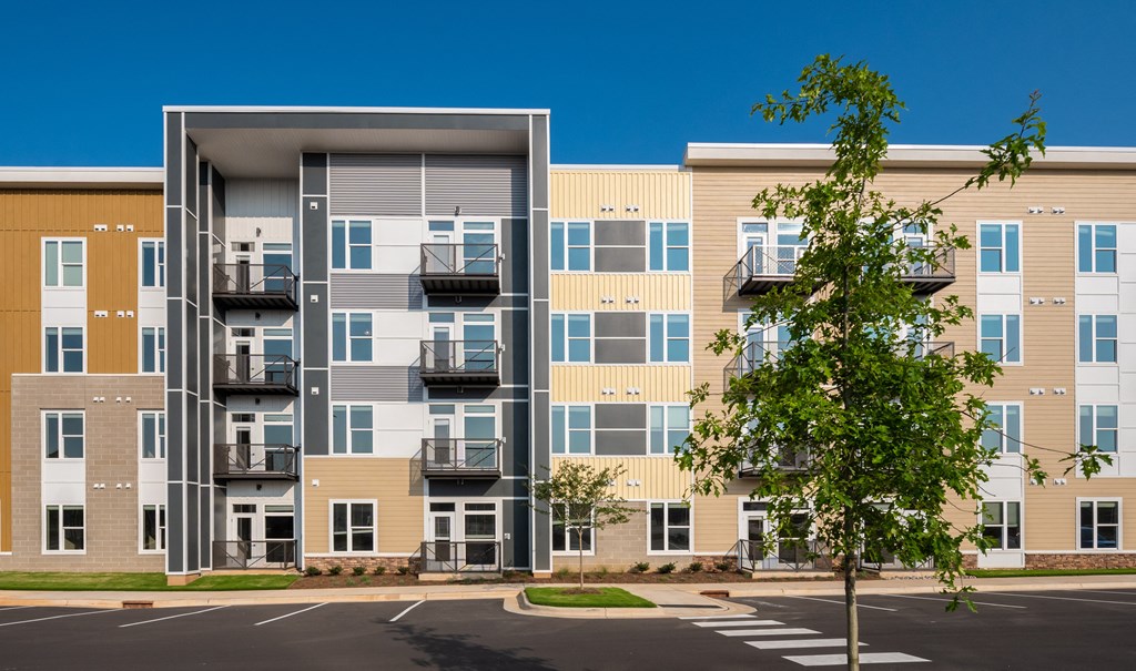 a picture of an apartment building with a tree in the foreground