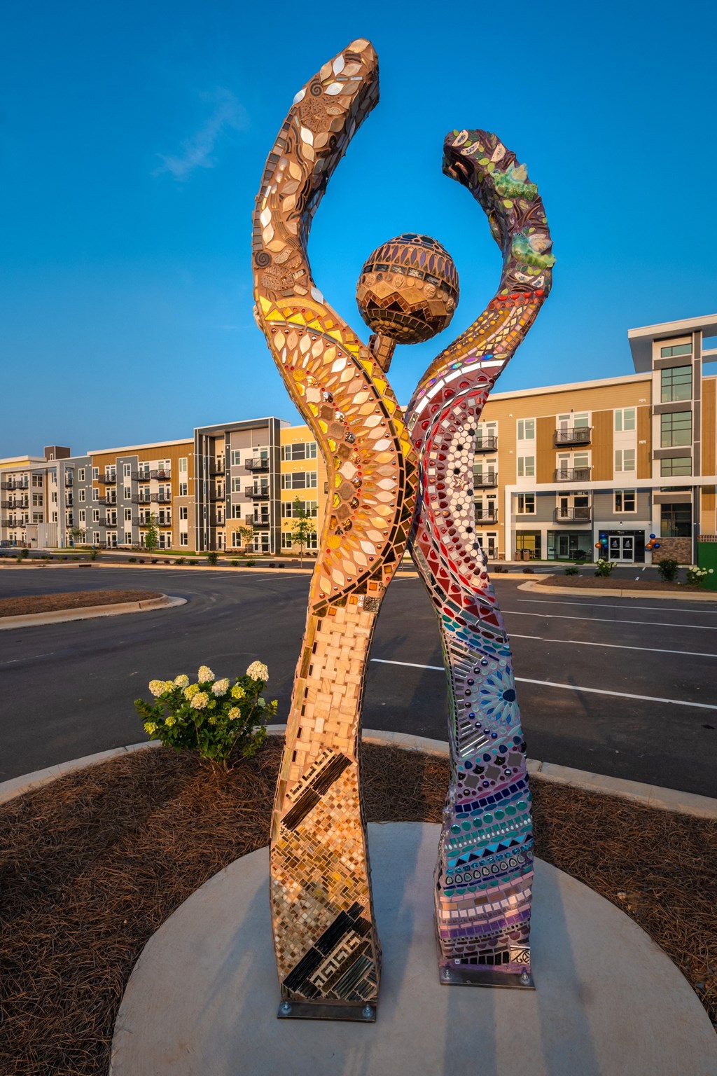 a colorful statue of a woman stands in front of a building