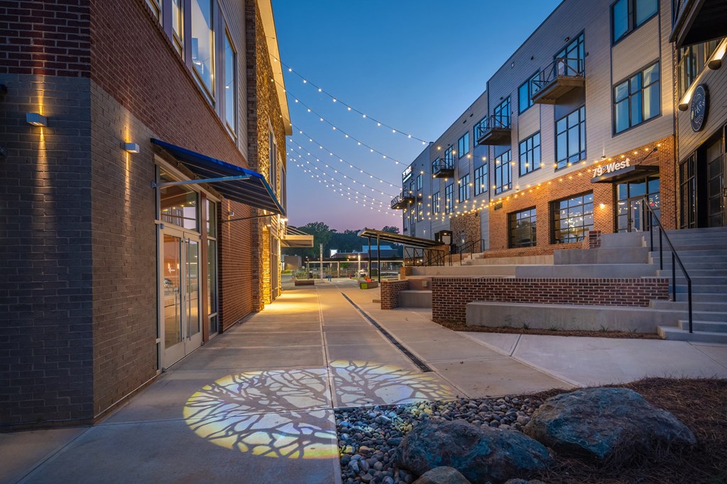 a mural of a sunflower painted on a sidewalk in front of a brick building