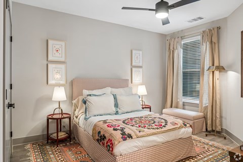 A bedroom with a large bed and a ceiling fan.