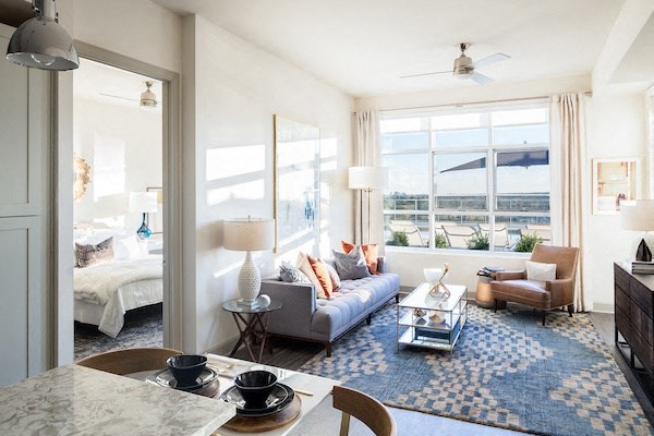 A living room with a large window and a view of the city.
