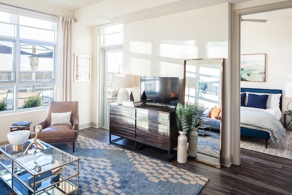A living room with a brown chair and a glass coffee table.