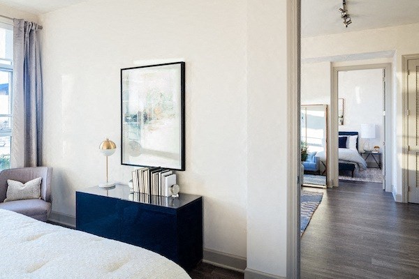 A bedroom with a large bed and a painting on the wall.