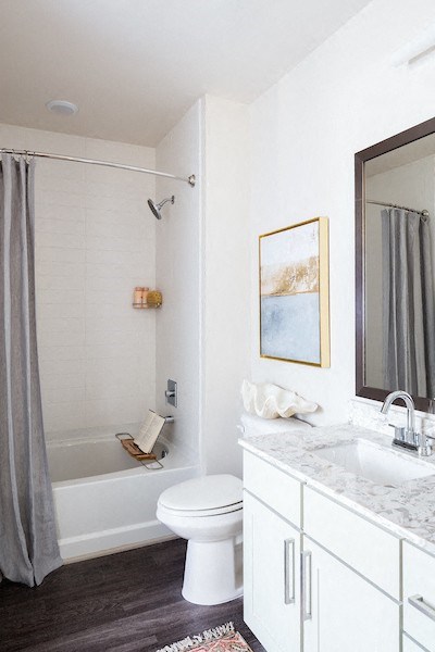 A white bathroom with a toilet, sink, and shower.