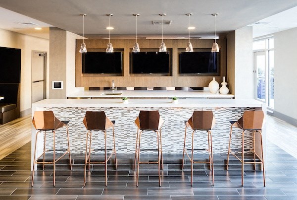 A modern kitchen with a bar area and chairs.
