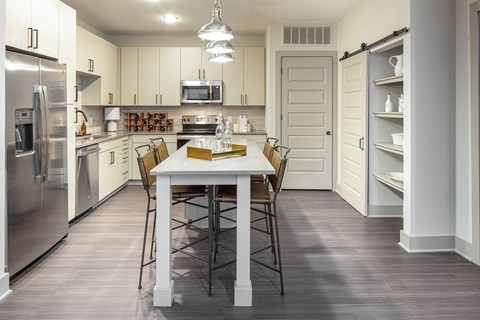 a kitchen with stainless steel appliances and a white table