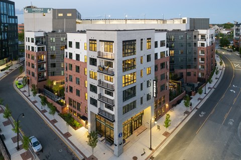an aerial view of an apartment building with a parking lot in the foreground