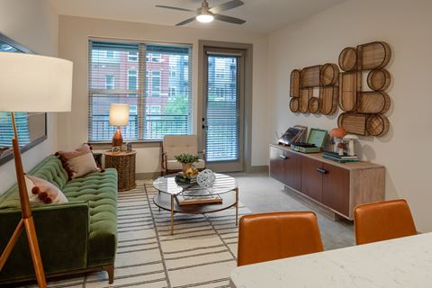 a living room with a green couch and orange chairs