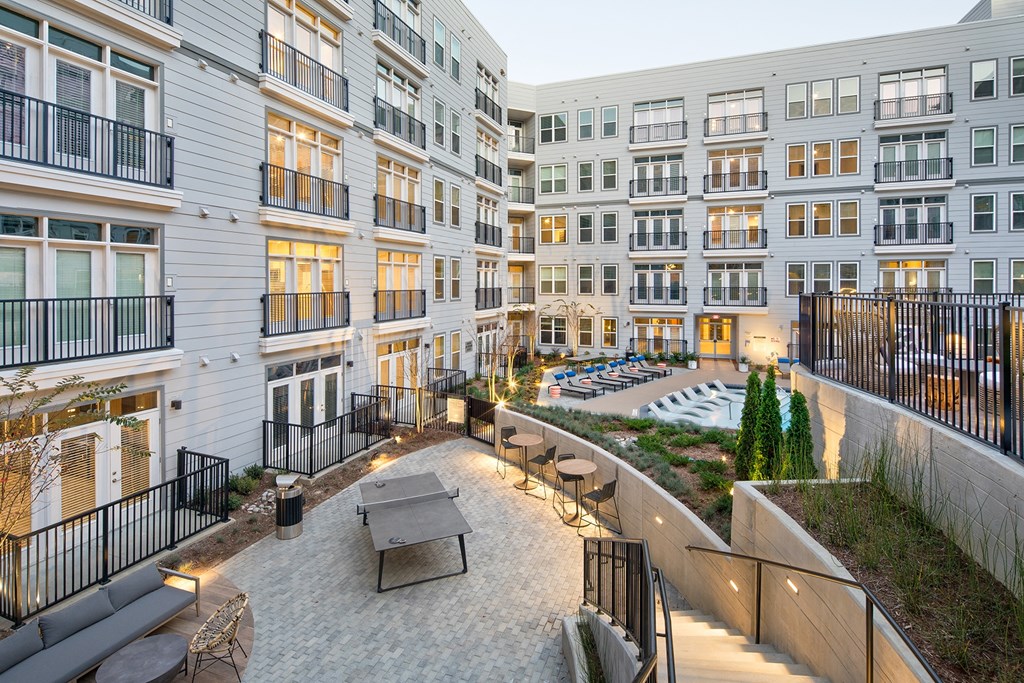 a courtyard in a large apartment building with tables and chairs