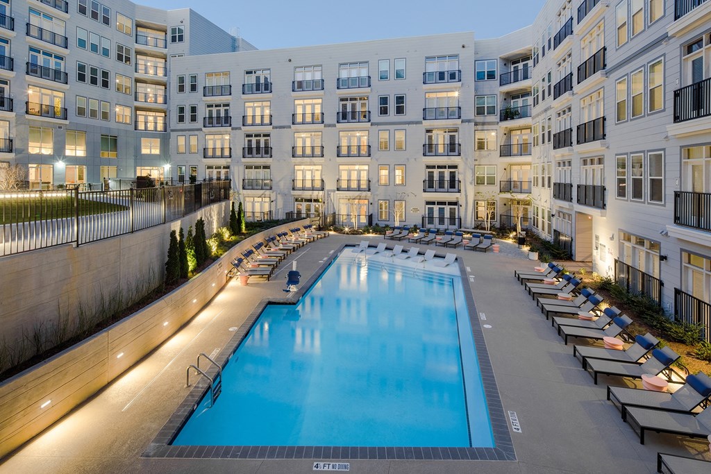 a large swimming pool in front of an apartment building