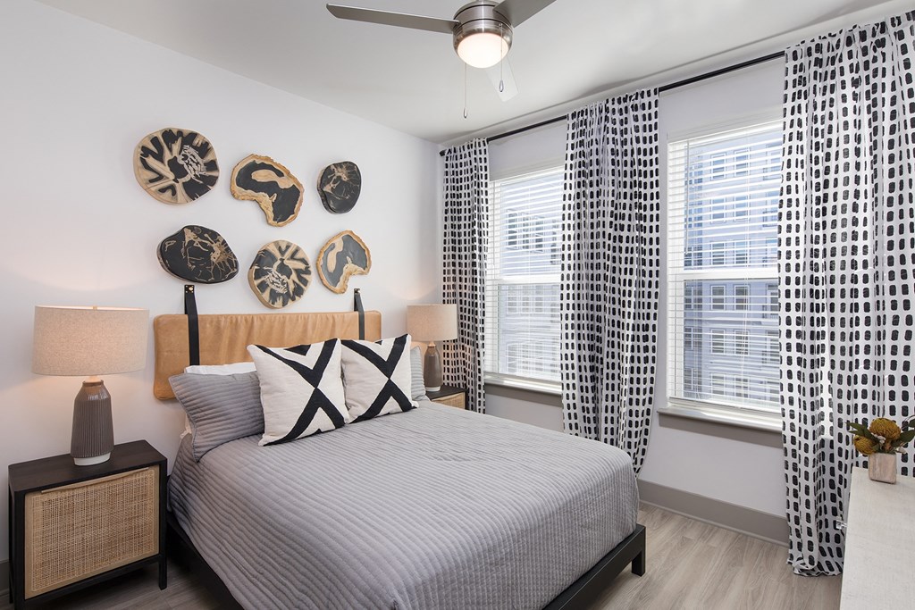 a bedroom with a bed and two windows