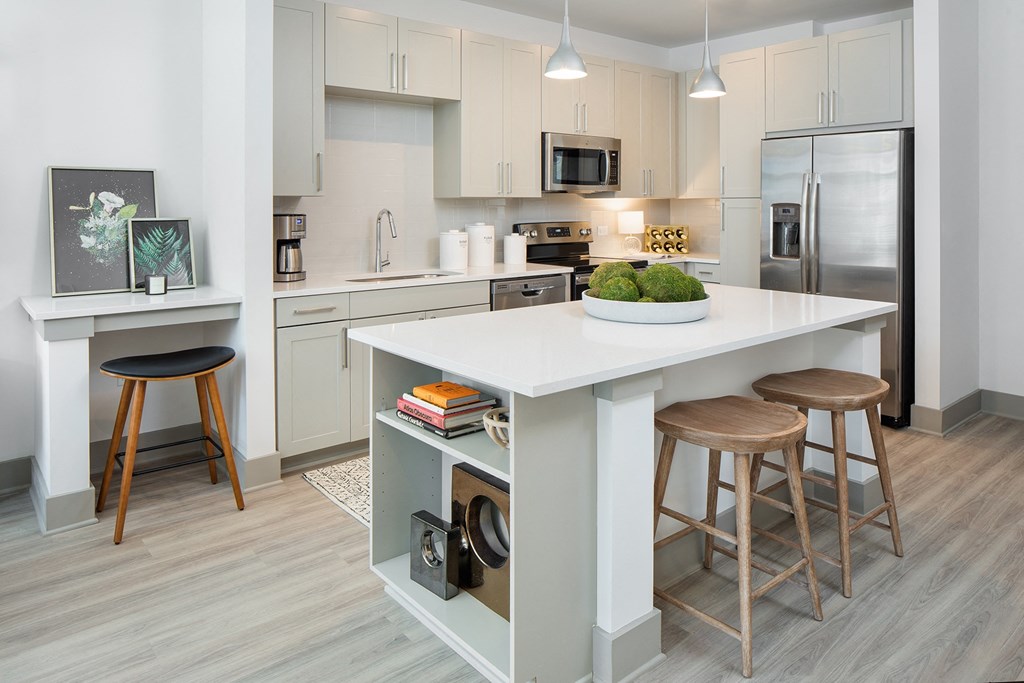 a kitchen with a large island with three stools