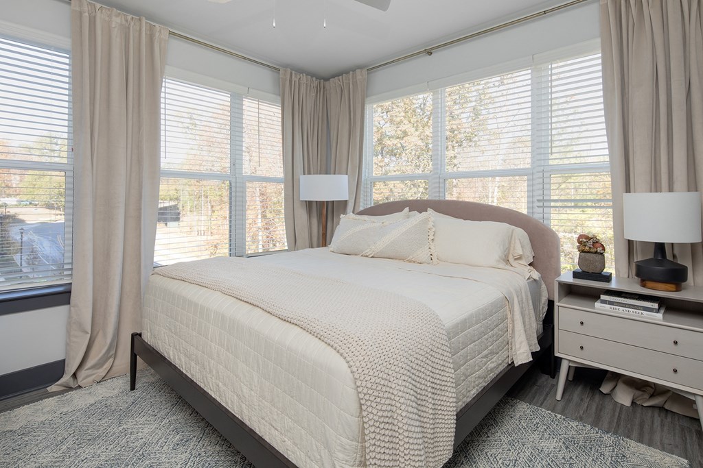 a bedroom with a bed and three windows