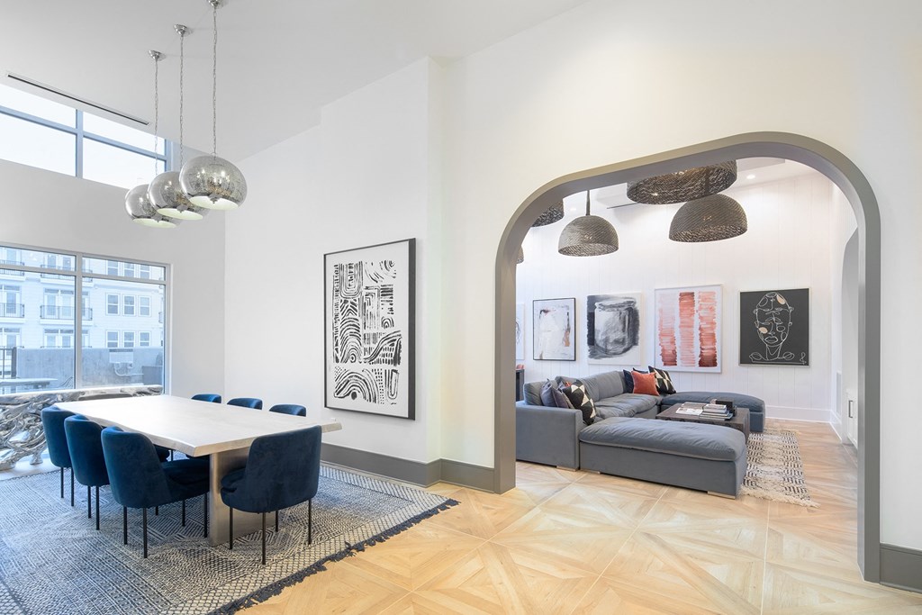 a dining room area with a table and chairs and a living room with a couch