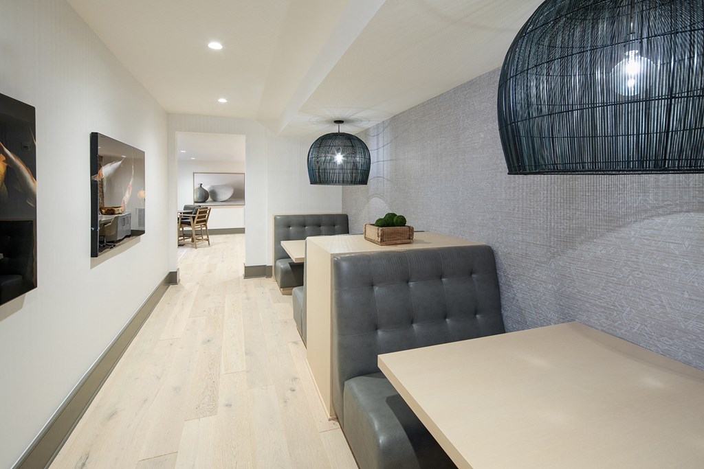 a dining room with a table and two leather chairs and a black chandelier