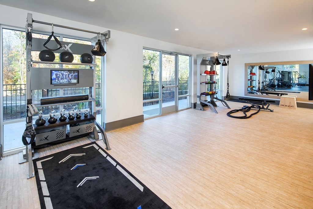 a home gym with a treadmill and weights on a wooden floor