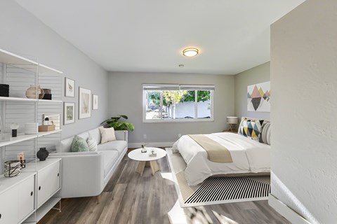 A modern bedroom with a white bed and a white couch.