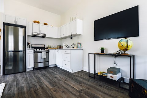 A modern kitchen with a black fridge and stove top oven.