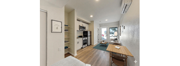 A kitchen with a table and chairs in front of it.