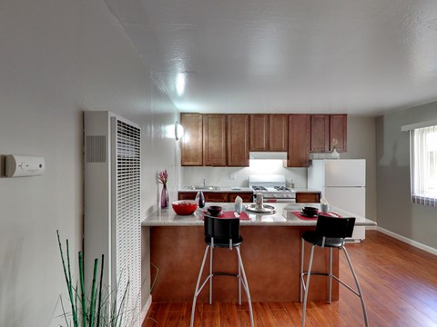 A kitchen with a white counter top and brown cabinets.