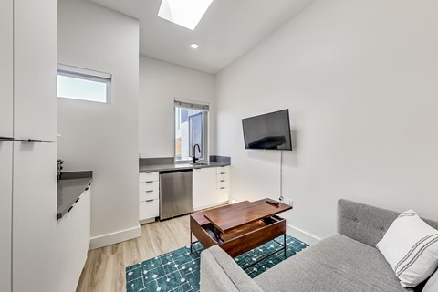 A modern living room with a grey couch and a wooden coffee table.