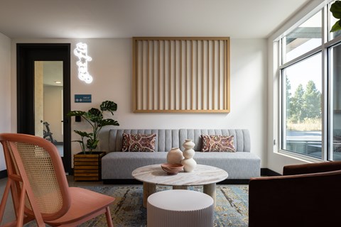 A living room with a grey couch, a round table, and a chair.