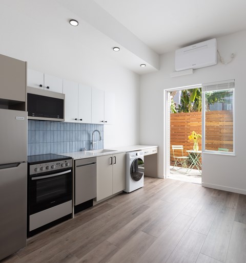 A kitchen with a stove top oven, microwave, dishwasher, and refrigerator.
