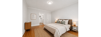 A bedroom with a large bed and a nightstand.