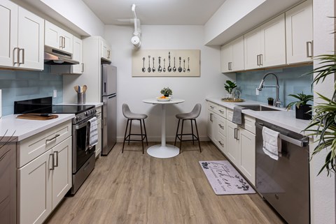 A kitchen with a table and chairs in the middle.