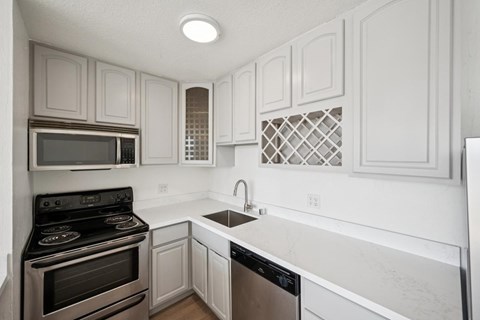 A kitchen with white cabinets and a black stove top oven.