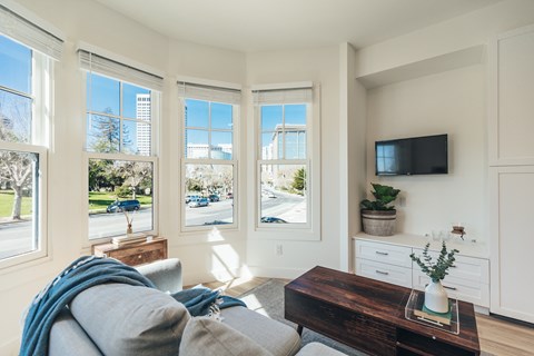 A living room with a grey couch and a wooden coffee table.