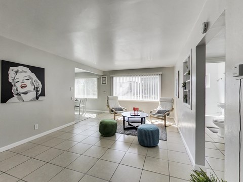 A living room with a large painting of Marilyn Monroe on the wall.
