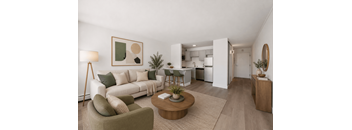 A modern living room with a white sofa, green armchair, and a wooden coffee table.