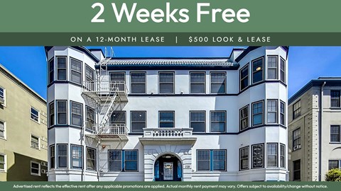 A white and black building with a sign offering 2 weeks free on a 12-month lease.