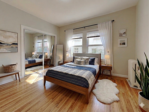 A bedroom with a large bed and a mirror on the wall.
