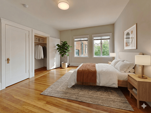 A bedroom with a bed, a nightstand, and a plant.