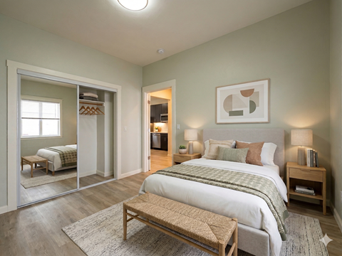 A bedroom with a large bed and a wooden bench.