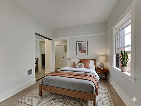 A bedroom with a large bed and a mirror on the wall.