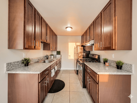 A kitchen with brown cabinets and a granite countertop.
