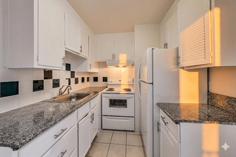 A kitchen with white cabinets and granite countertops.