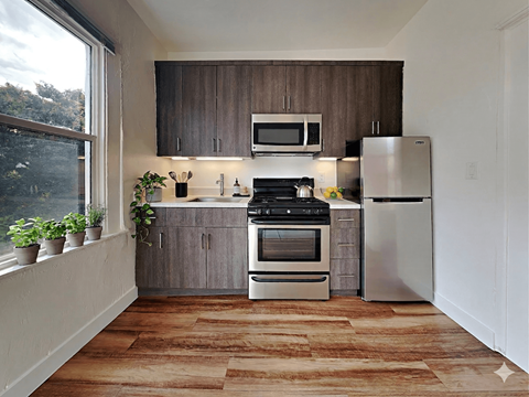 A kitchen with a stove top oven and a refrigerator.