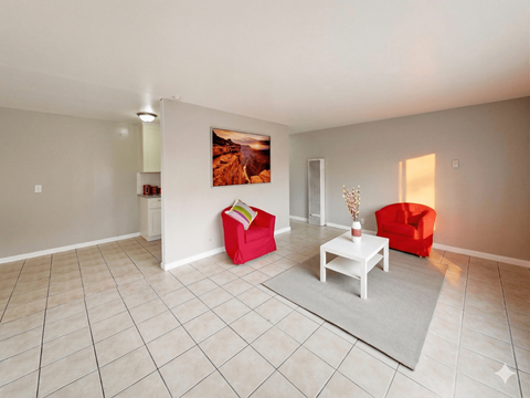 A living room with a red chair and a white coffee table.