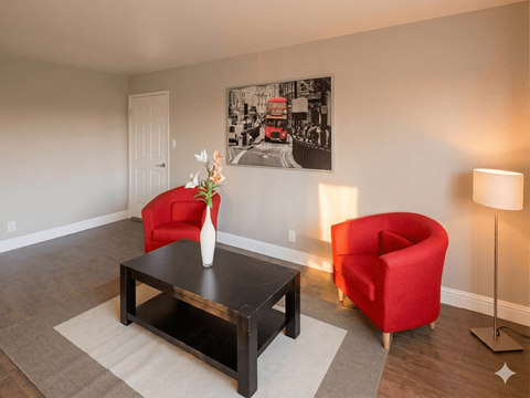 A living room with a red chair and a coffee table.