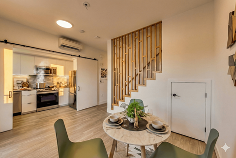 A modern kitchen with a dining table set for two.