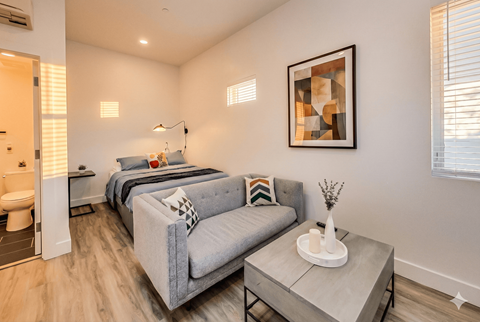 A modern living room with a grey couch and a coffee table.