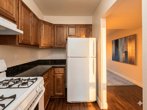 A white refrigerator in a kitchen with wooden cabinets.